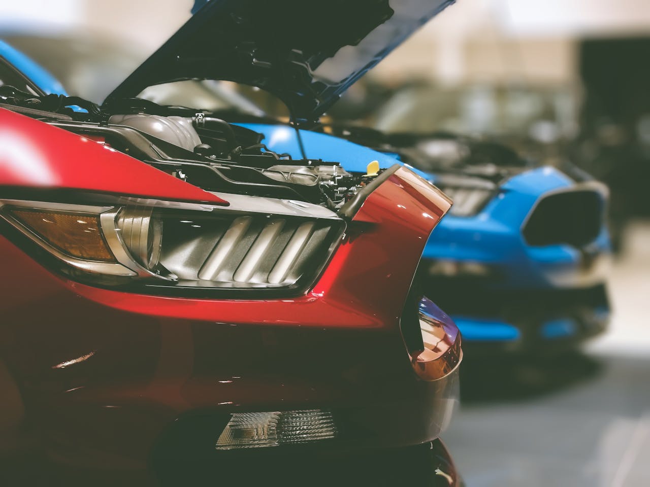 Detailed view of a red luxury sports car with its hood open, showcasing automotive design.