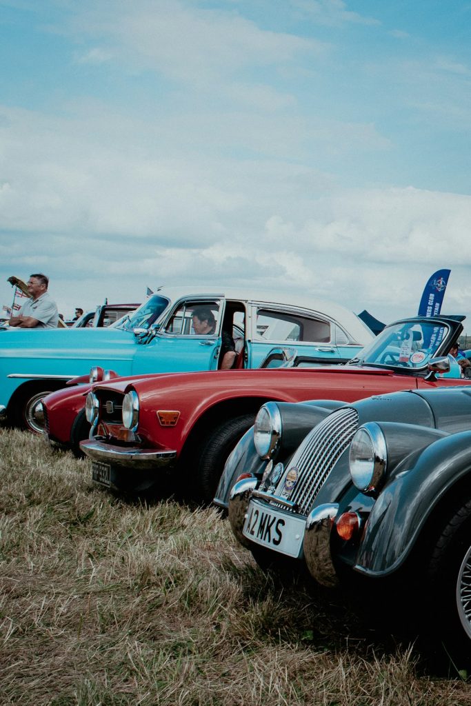 red-and-black-vintage-car-on-green-grass-field-during-daytime-nocqixl1kq4